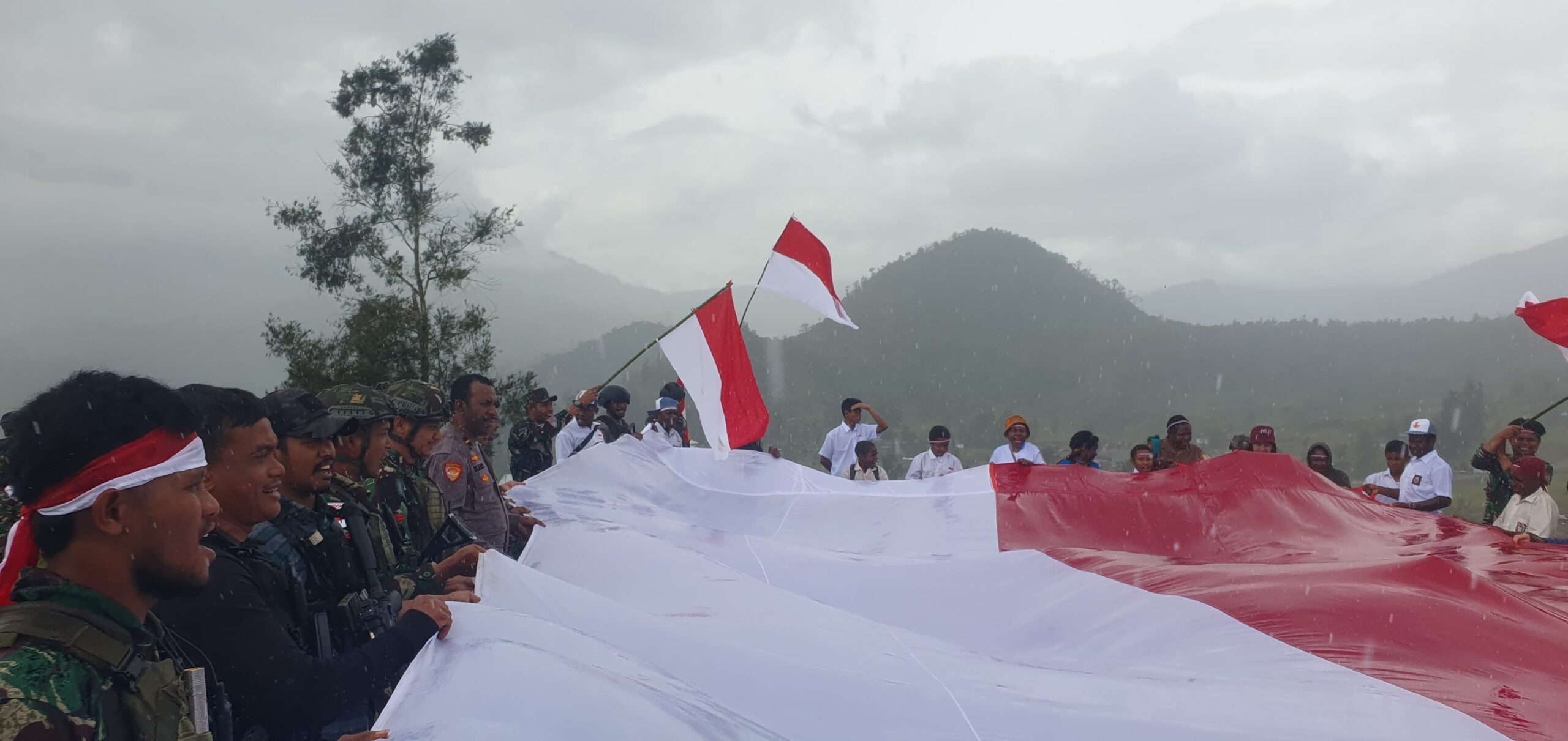 KEMERIAHAN KIRAB DAN PENGIBARAN BENDERA MERAH PUTIH OLEH HABEMA DAN MASYARAKAT SINAK