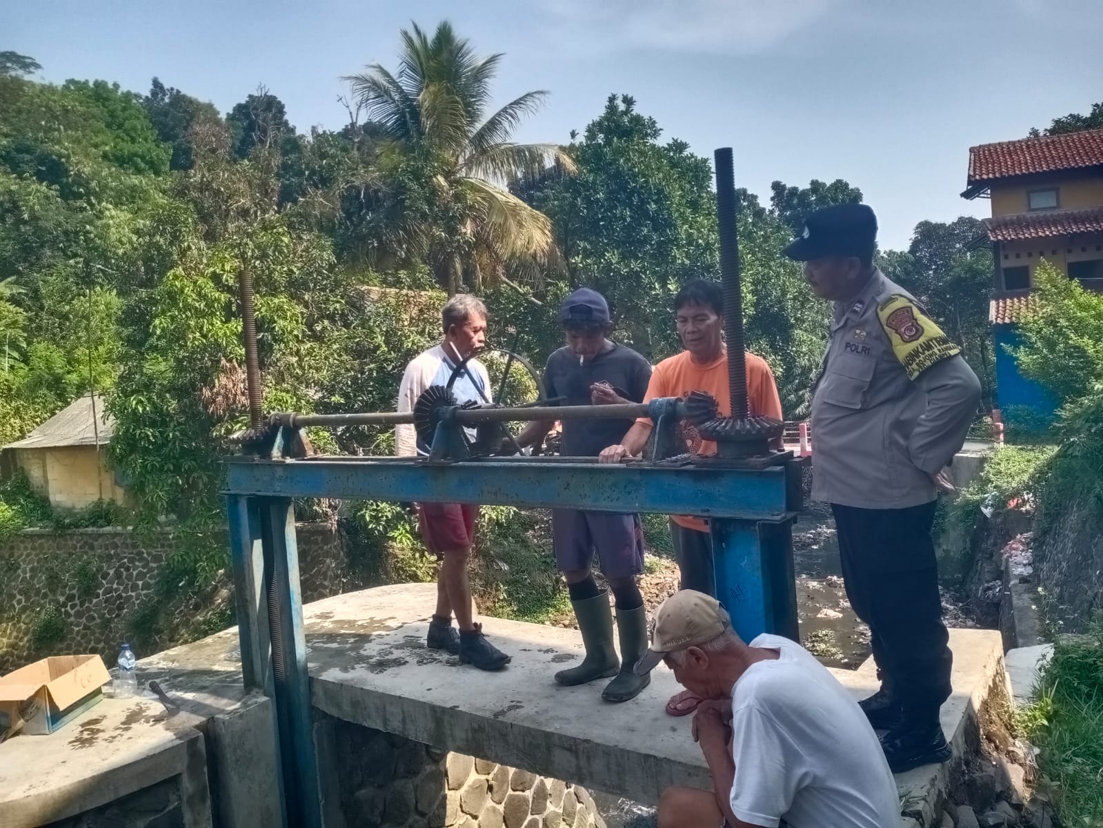 BHABINKAMTIBMAS WILAYAH HUKUM POLSEK CIAMPEA GIAT MEMANTAU WARGA DI LINGKUNGAN RW 01KP. WARUNG BORONG DS BOJONGRANGKAS MEMBERSIHKAN SALURAN IRIGASI SUMBER AIR CIBODAS