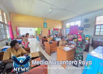 Babinsa koramil 1705-01/Nabire bagikan lembar kuisiuner tentang program makan bergizi di sekolah. 