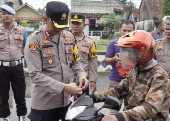 Polres Lampung Tengah Gelorakan Nasionalisme: Bagikan dan Pasangkan Bendera Merah Putih kepada Pengendara