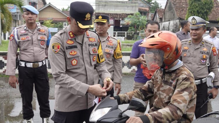 Polres Lampung Tengah Gelorakan Nasionalisme: Bagikan dan Pasangkan Bendera Merah Putih kepada Pengendara