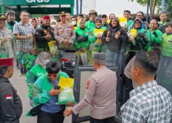 Wakasat Bimas Polres Metro Bekasi Bagikan Beras ke Ojek Online di Shelter Grab Lippo Cikarang